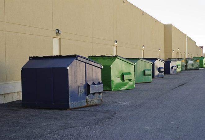 construction workers disposing of debris in large dumpsters in Landers